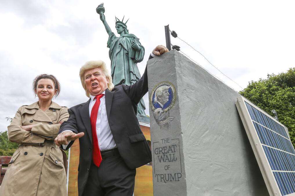 Great wall of Trump: Jacqui Lambie and impersonator 'The Unreal Donald Trump' stand by the new wall between the US and Mexian embassies at the Village of Lower Crackpot. Pictures: Cordell Richardson