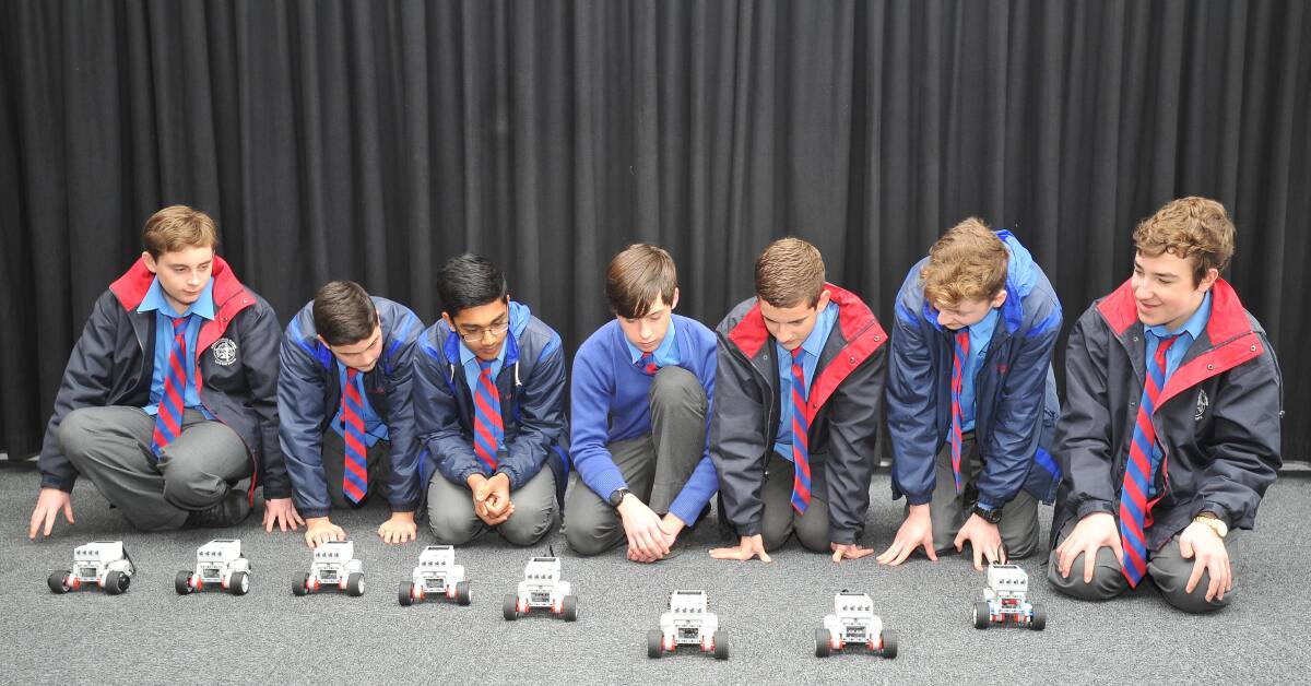 HARD AT WORK: Kildare Catholic College students show off their robots after a long day programming them to perform a series of tasks. 