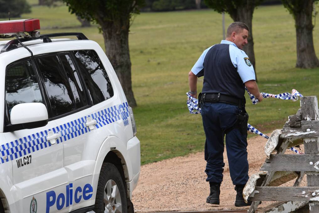 Property raid: Walcha Sergeant Anthony Smith cordons off the Pandora property near Walcha with crime scene tape on Saturday morning as police search the home. Photo: Gareth Gardner
