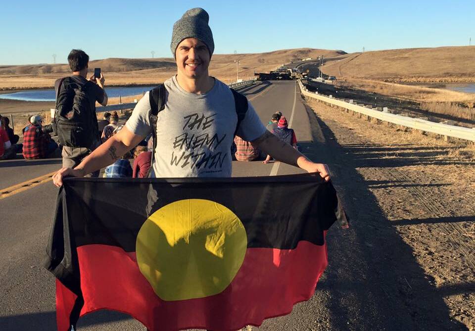 MERGING CULTURES: Joe Williams waves the Aboriginal flag at Standing Rock Indian Reservation in the United States earlier this month.