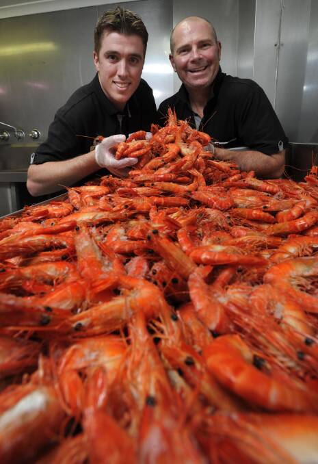 South Wagga Butchery owner Liam Hanigan and meat manager Raymond Farrell prepare for the rush of customers stocking up on fresh seafood today for Good Friday. Picture: Les Smith