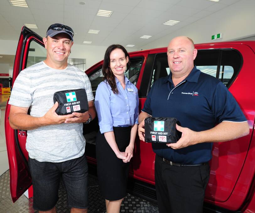 SAFETY FIRST: Senior firefighter Aaron Campbell and Michelle Bray and Col McGill from Thomas Bros with the first aid kits now included in new cars. Picture: Kieren L Tilly