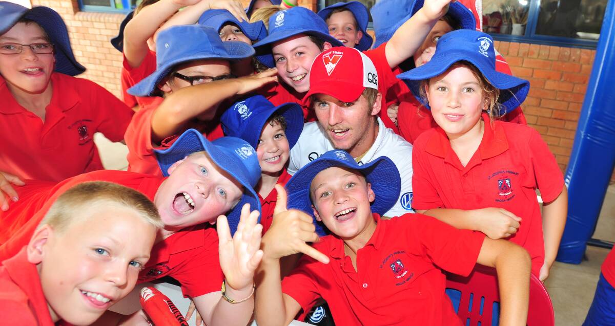 MR POPULAR: Students at St Josephs Primary School flock Sydney Swans player Sam Murray as part of the AFL Community Camp on Tuesday. Picture: Kieren L Tilly