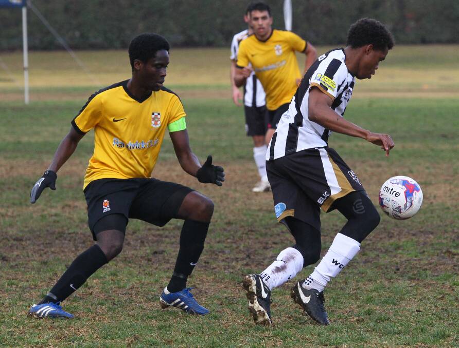 MAN ON: Wagga City Wanderers' Chinedu Arinze looks to pass as University of NSW's Lenox Tweneboa applies pressure at Gissing Oval on Saturday. Picture: Les Smith