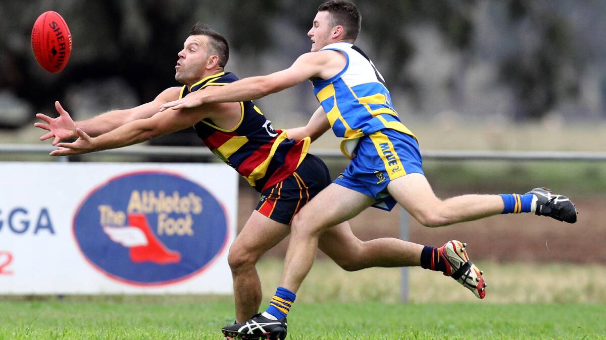 FULL STRETCH: Leeton-Whitton forward Michael Wescombe tries to bring in a mark despite pressure from Leeton-Whitton's Patrick Griffin at Mangoplah Sportsground on Saturday. Picture: Les Smith