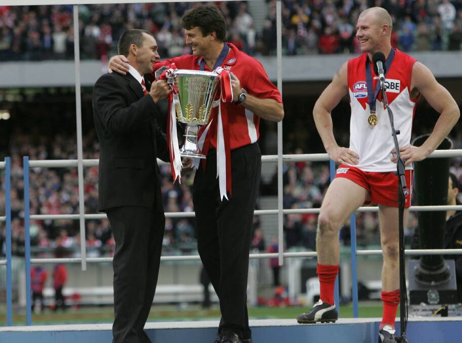 SPECIAL MOMENT: Paul Kelly presents the 2005 AFL Premiership Cup to Paul Roos and Barry Hall.