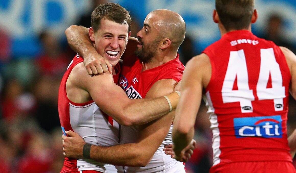 HAPPY DAYS: Harry Cunningham is flocked by Rhyce Shaw after kicking a goal that sealed the Swans' win over Port Adelaide on Thursday night.