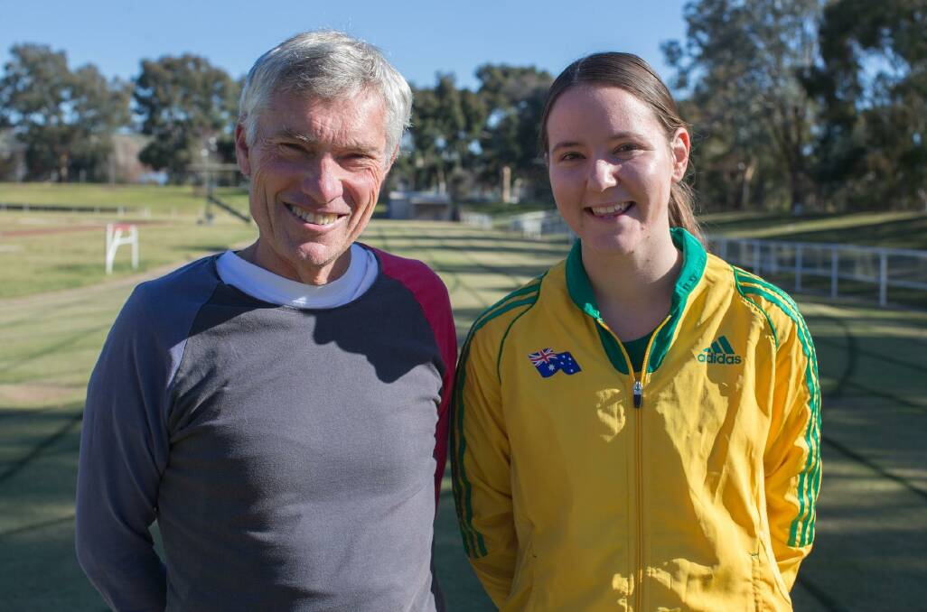OVER THE MOON: Wagga athlete Carly Salmon shows off her Australian colours with coach Mark Conyers at Jubilee Park this week.