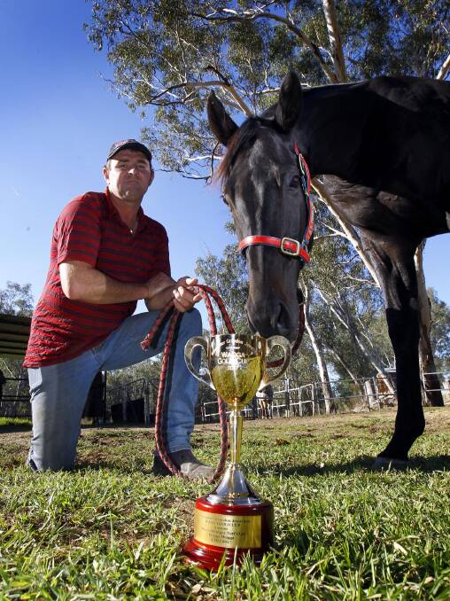 GOING FOR GLORY: Trainer Trevor Sutherland and Gentleman Max inspect the Wagga Gold Cup before Friday's feature race at Murrumbidgee Turf Club. Picture: Les Smith