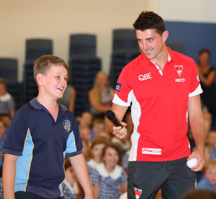 GOOD TIMES: Sydney Swans' Colin O'Riordan has some fun with Bailey Woods at Holy Trinity Primary School on Monday. Picture: Kieren L Tilly