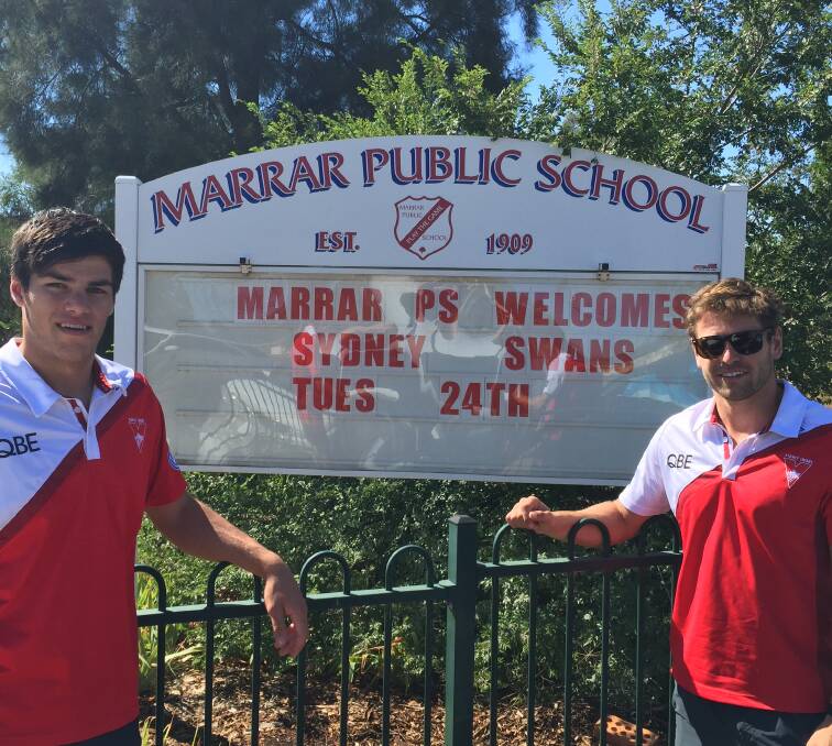 COUNTRYSIDE: Sydney Swans players Lewis Melican and Nick Smith are greeted by a special welcome at Marrar Public School on Tuesday. Picture: Contributed 