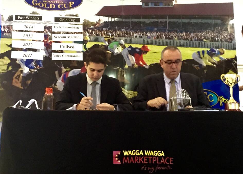 SERIOUS BUSINESS: Southern District stewards Troy Vasallo and John Davidson conduct the Wagga Gold Cup barrier draw at the Wagga Marketplace on Tuesday morning. Picture: Matt Malone