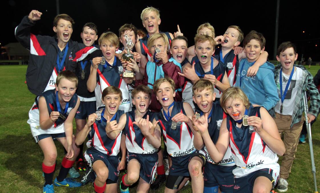 CHAMPIONS: Mater Dei Primary School students celebrate their Paul Kelly Cup win at Robertson Oval on Monday night. Picture: Les Smith