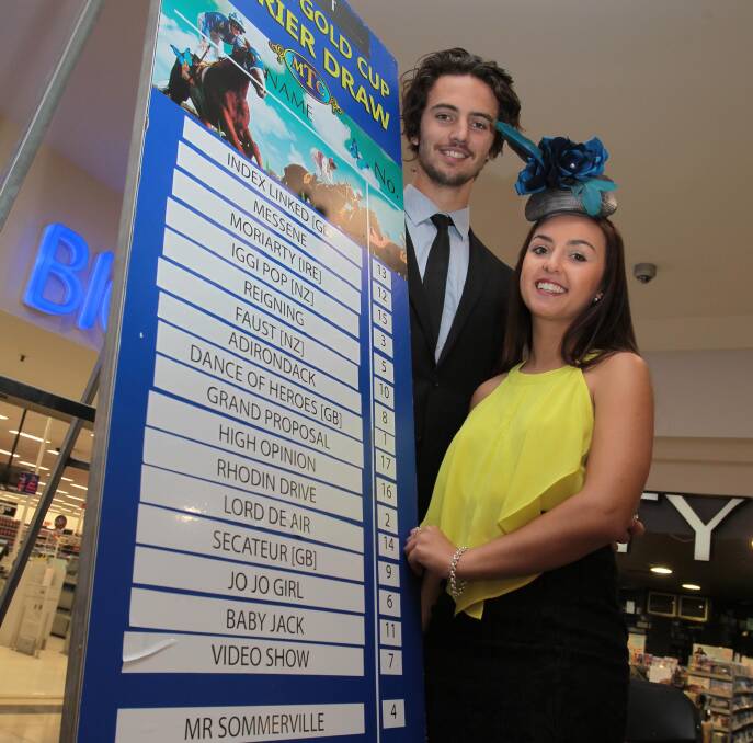 ALMOST TIME: Faces of the Carnival Brad Graham and Emily Everett show off the final field for the Wagga Gold Cup at the official barrier draw at Wagga Marketplace on Tuesday. Picture: Les Smith