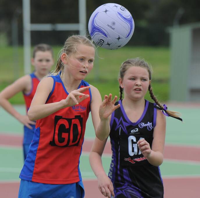 QUICK PASS: Marian Cheetahs' Lucy Barkla offloads the ball despite pressure from Shooting Stars Magic's Cleo Buttifant in the 11 years division one grand final on Saturday. Picture: Laura Hardwick