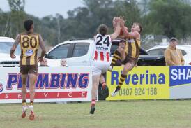 East Wagga-Kooringal's Jeremy Piercy goes back with the flight to mark against Charles Sturt University's Dusty Rogers in the Farrer League game at Gumly Oval on Saturday. Picture by Tom Dennis