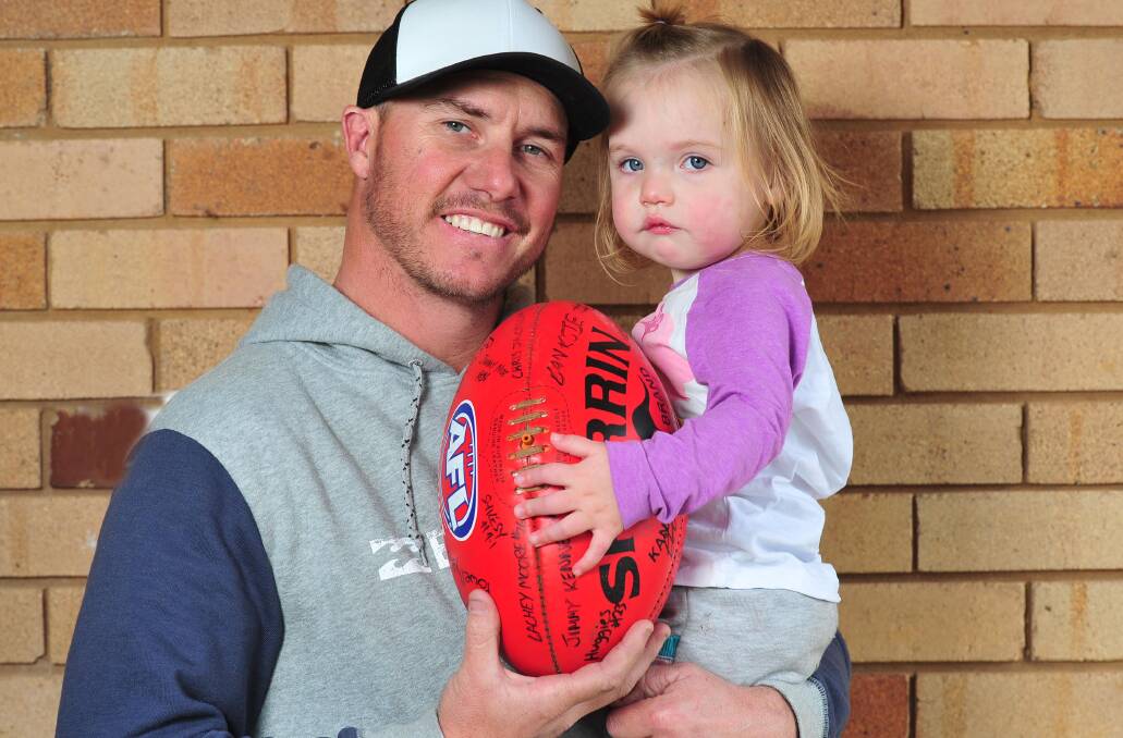 ALMOST FINISHED: Retiring Collingullie-Glenfield Park star Brad Aiken with daughter Emlee at home in Wagga on Wednesday. Picture: Kieren L Tilly
