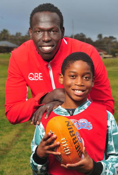 NEW FRIENDS: Sydney Swans' Aliir Aliir with talented 10-year-old Wagga athlete Frankleen Newah Jarfoi at French Fields in Wagga on Thursday. Picture: Kieren L Tilly