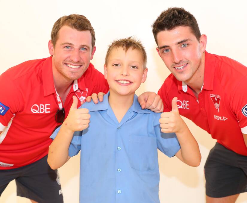 Hugo Gray, 10, gives the thumbs up to the visit of Sydney Swans players Harry Cunningham and Colin O'Riordan at Holy Trinity Primary School on Monday. Picture: Kieren L Tilly