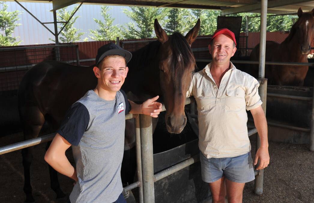 HAPPY DAYS: Nick Heywood (left) with his father Chris and High Opinion at his Wagga stables. Nick rode his first city winner on Wednesday. Picture: Laura Hardwick