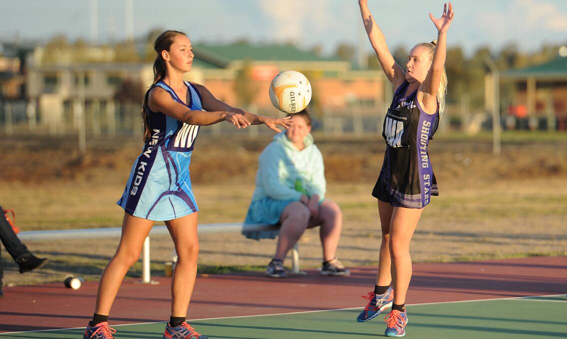 SPEED: New Kids Aces' Abbey Corbett gets a pass away in the opening round Wagga netball clash last Saturday against Shooting Stars' Brodie Jaques. Picture: Laura Hardwick
