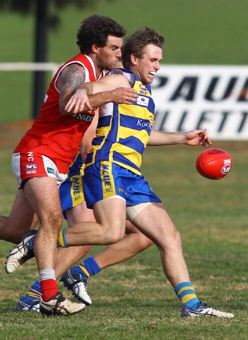 TIGHT: MCUE's Ryan Price looks to get boot to ball despite pressure from Collingullie-Glenfield Park's Mick Anderson at Crossroads Oval on Saturday. Picture: Les Smith