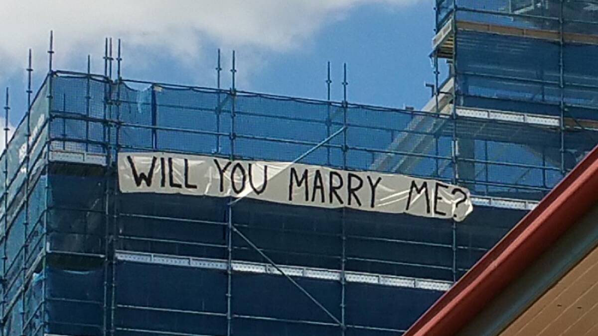 HOPELESS ROMANTIC: Ricky Jenkins proposed to his now fiance Amy Ryan by erecting a sign on the side of the Wagga Base Hospital construction site where he is currently working as a labourer. Picture: Nicole Barlow