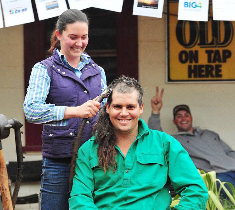 CUT FOR A CAUSE: Amie White trims her fiancée Brett Buerckner's hair in Marrar on Saturday before their October wedding and to raise money for SIDS. Picture: Kieren L Tilly