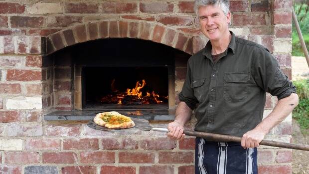 Matthew Evans pulls a pizza out of Dennis the brick oven. Photo: Sofia Levin
