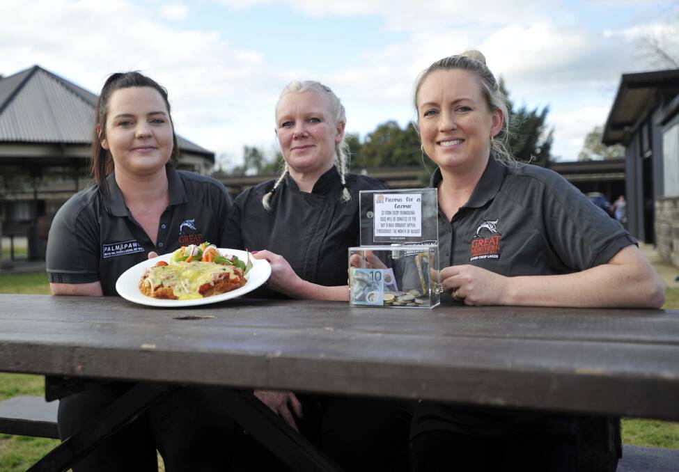 DIGGING DEEP: Palm and Pawn staff Baillie Merlehan, Bek Day, and Tanya Duncan have been busy serving up tasty chicken parmigiana to help our farming communities. Picture: Chelsea Sutton