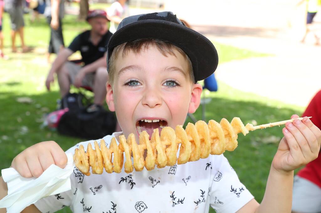 PLEASED AS PUNCH: Wagga's Jack Hinchcliffe, 6, devouring his chips on a stick at the new-look gourmet Gumi World Championship Race thanks to the team at Cork and Fork. Picture: Kieren L Tilly