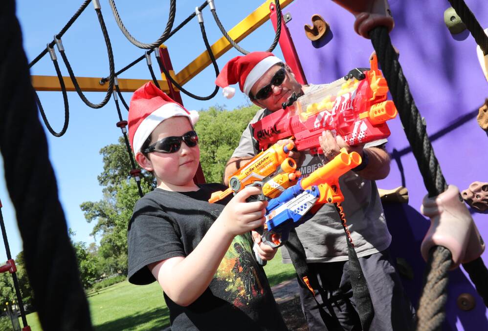 READY, AIM, FIRE: Andrew Goldstraw and his son, William, are gearing up for this weekend's Christmas Nerf gun battle, and they want you to get in on the fun, too. Picture: Les Smith
