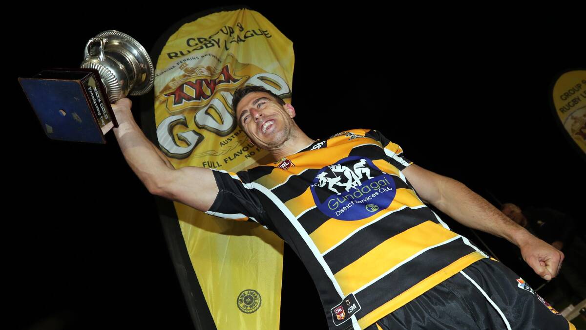 MISSION ACCOMPLISHED: Gundagai captain-coach James Smart raises the premiership cup in his fifth attempt to win a Group Nine grand final. Picture: Les Smith