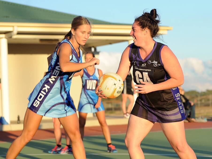 NEW START: Flynn Hogg looks for options in her move into the Shooting Stars A grade team against New Kids Aces' Rhainnon Podmore on Saturday.