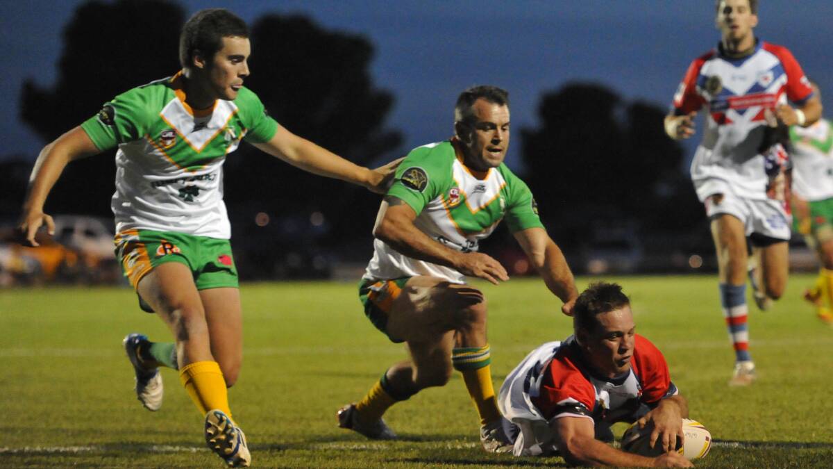 Kangaroos' Brent Blackstock goes over for a try as Orange CYMS' Luke Petrie and Sam Jones look on in last year's West Wyalong Knockout.