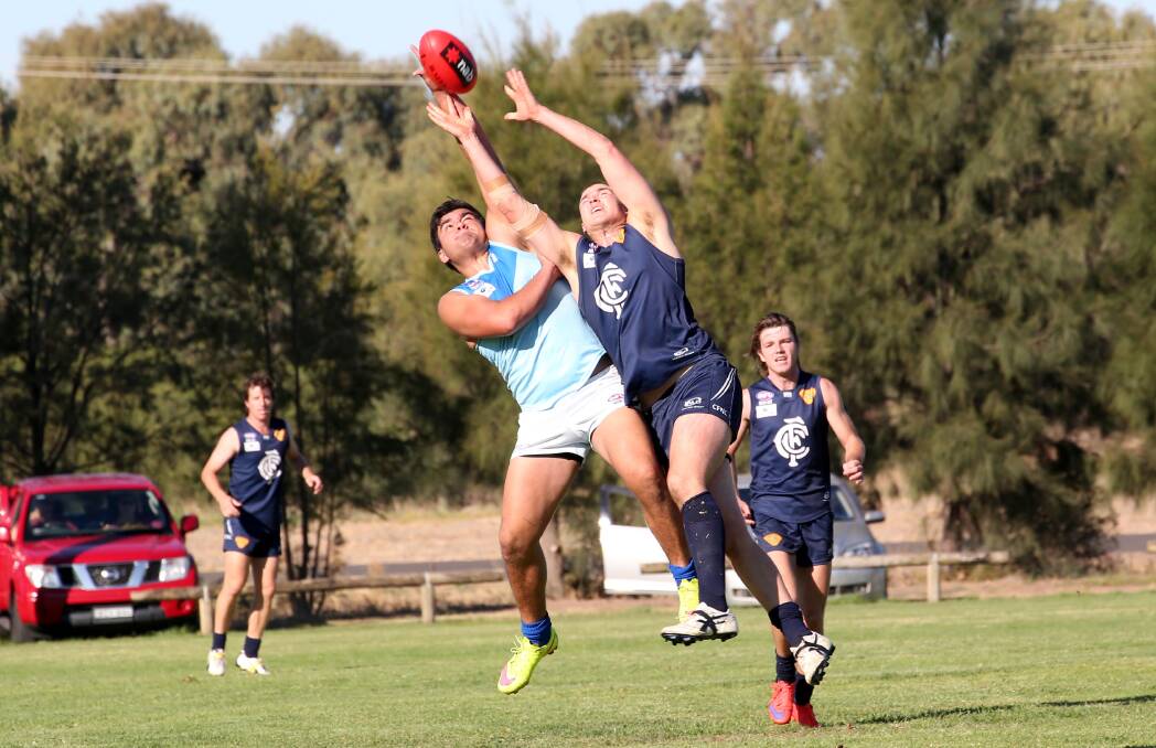 STRONG HANDS: Coleambally's Josh Hamilton looks to take a mark over Barellan's Jarrod Moala as the Blues brought up their first win of the year. Picture: The Area News