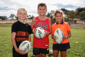 Estella Public School students Tyson Dunstan, 8, Lucas Diaz, 9, and Sophia Diaz, 8, get a taste of rugby league as a new club looks to provide an avenue to the sport closer to home. Picture by Tom Dennis