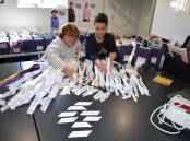 Wagga Women's Health Centre's Mary-Ellen Bradley and director Johanna Elms prepare white ribbons for the No More rally in Wagga on Sunday. Picture by Taylor Dodge