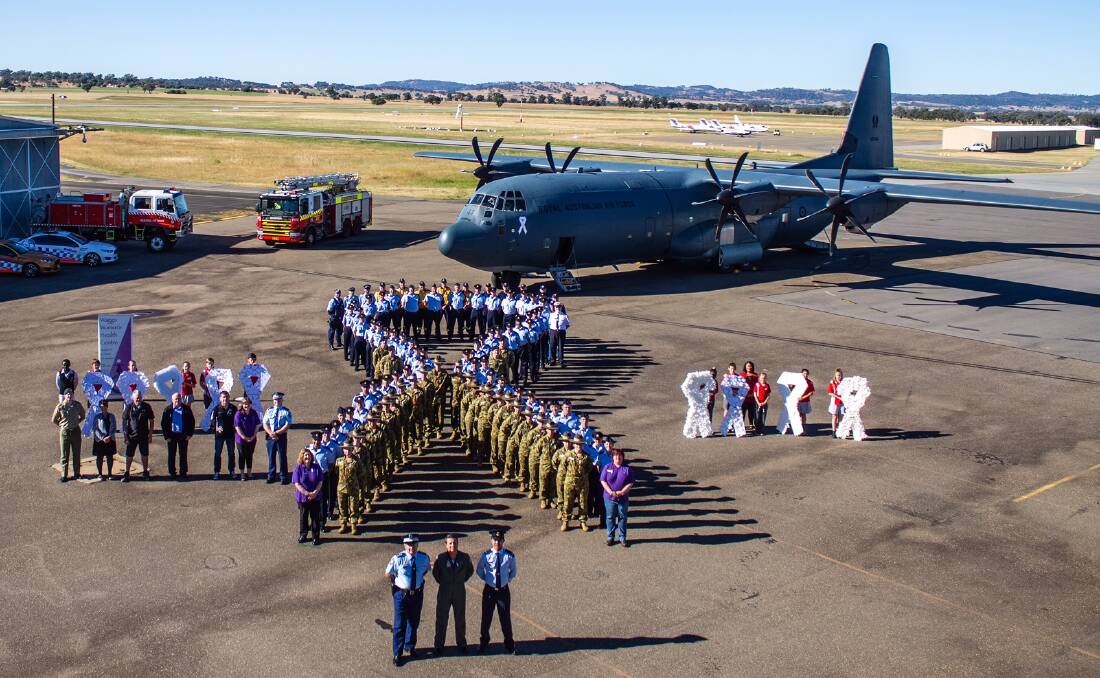 PROUD STANCE: Wagga White Ribbon Day supporters form an inspiring symbol at the Forest Hill RAAF base last Friday.