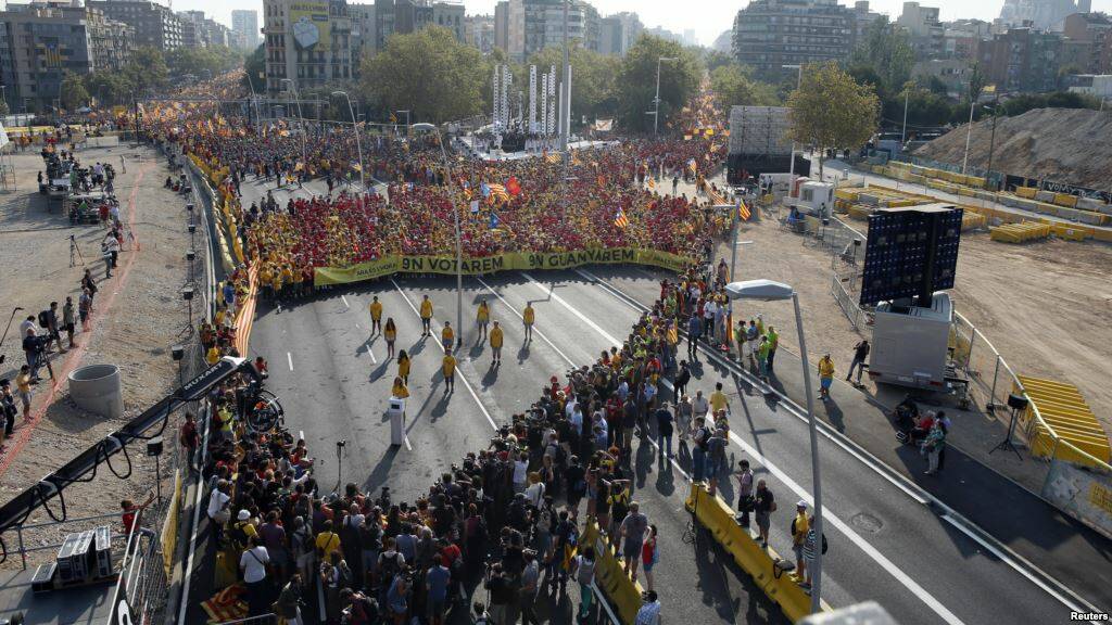 Thousands of Catalans form a 'human V' in Barcelona. A community group is asking locals to do a similar thing to support Volunteer Week next week.