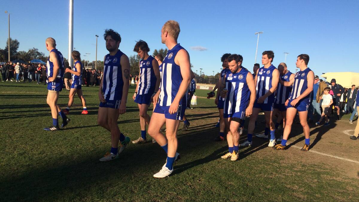 DEJECTED: Temora players make their way to the presentation as, in the background, Marrar's celebrations get into full swing. 