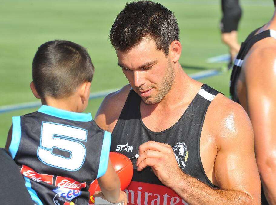 Levi Greenwood signs a young fan's footy. Picture: Kieren L Tilly