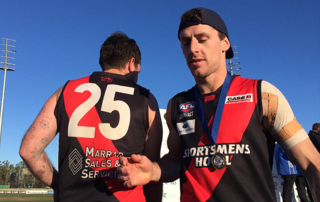 Brad Turner with his medal as another of the Bombers' best, midfielder Shannon Williams, goes up to collect his.