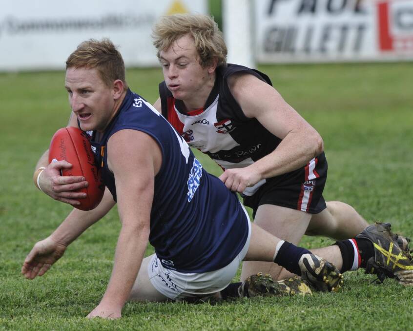 IT'S MINE: Coleambally's Wes Kiley holds on tight as North Wagga's Sam Longmore looks to wrap him up. Picture: Les Smith