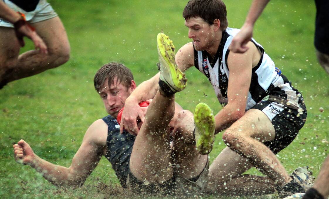 WET WEATHER FOOTY: Coleambally's Jackson Painting holds it in tight as The Rock-Yerong Creek's Charlie White closes in. Pictures: Les Smith