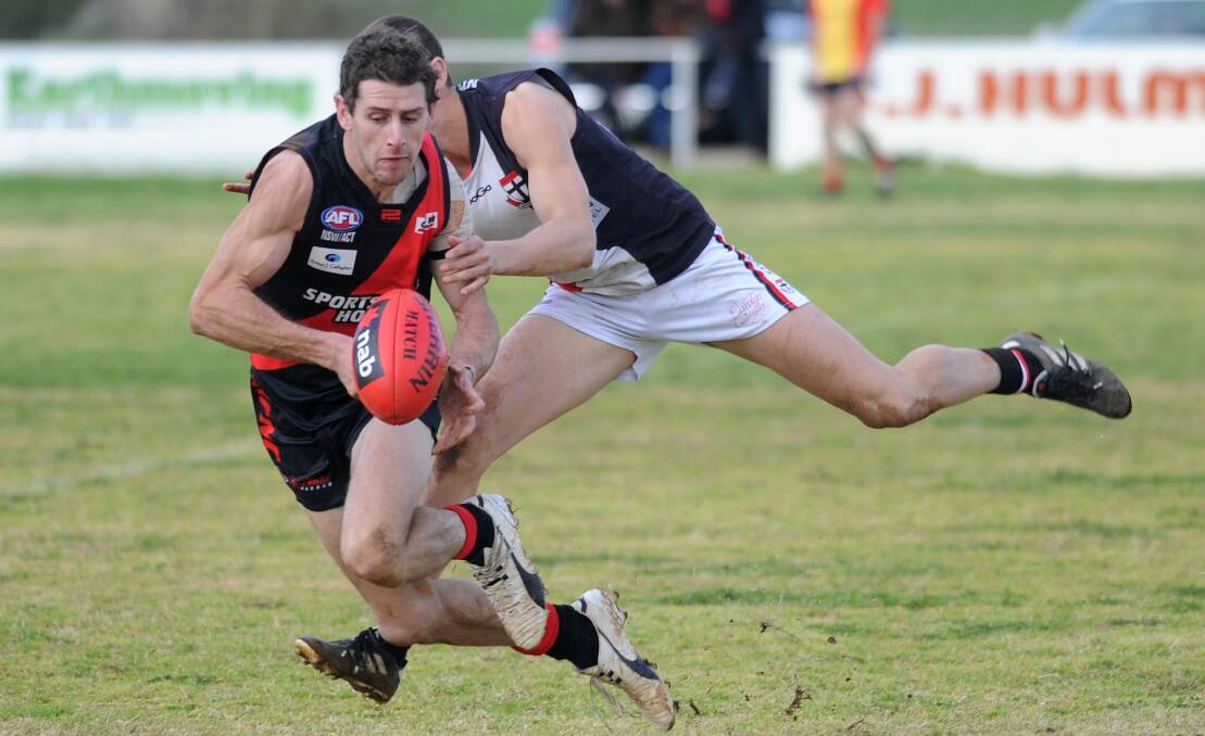 BIG DAY: Marrar forward Brad Turner has eyes only for the ball in his 100th game for the Bombers, as North Wagga defender Troy Curtis keeps the heat on. Picture: Laura Hardwick