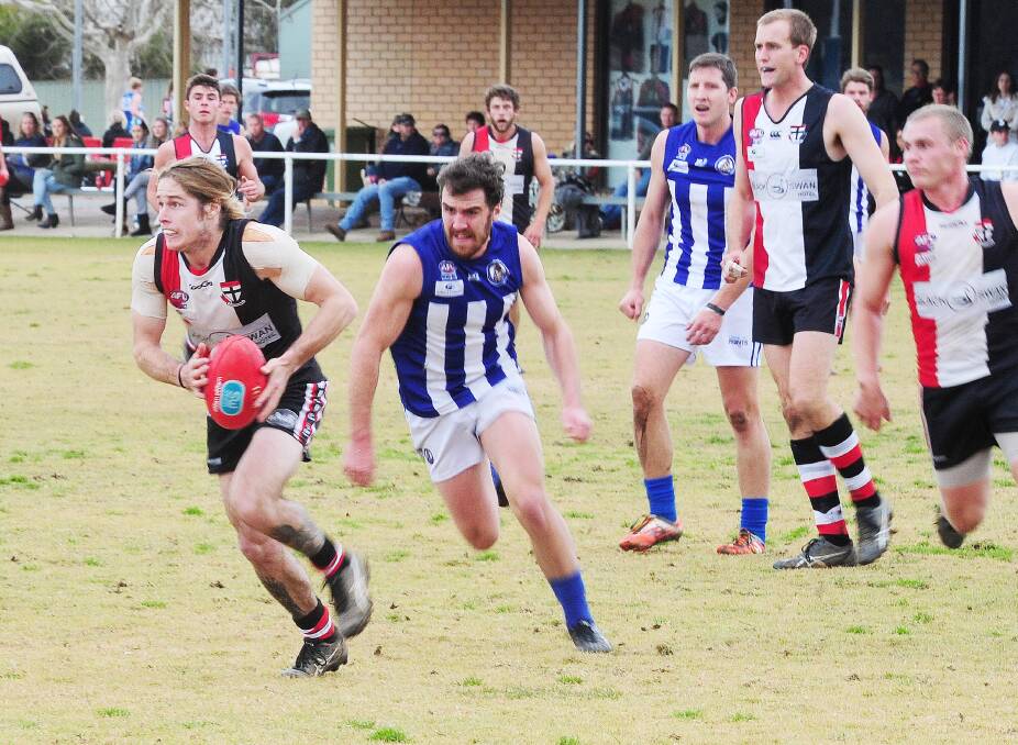 THE EYES HAVE IT: North Wagga's Corey Watt tries to get the Saints going forward as Temora midfielder Kieran Shea closes in at McPherson Oval on Saturday. Picture: Kieren L Tilly
