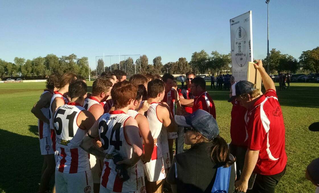 MOMENTOUS DAY: CSU players listen to coach Daniel Athanitis' three-quarter-time speech before delivering the club's first win of the year.