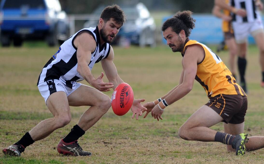 MESMERISED: TRYC coach Tom Yates and the Hawks' Brocke Argus have eyes only for the ball at Gumly Oval on Saturday. Picture: Laura Hardwick