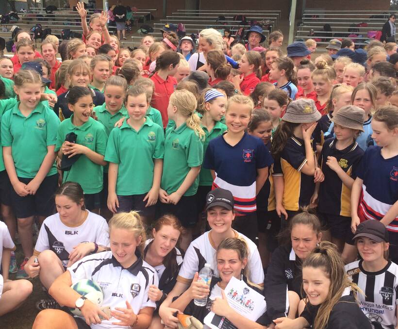 DRAWING A CROWD: Former Matilda Sally Shipard is almost lost in a sea of smiling faces at Wagga's Conolly Park on Friday. Shipard made a flying visit to drop in on the mini Matildas gala day. Picture: Peter Doherty